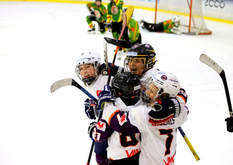 Štyria hokejisti sa tešia z gólu